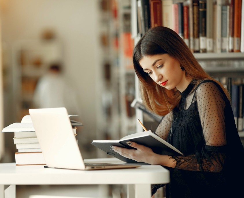 Studentin liest in Bibliothek